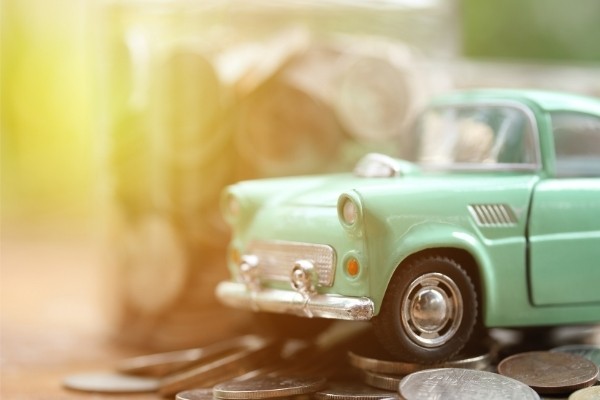 A toy classic car and coins