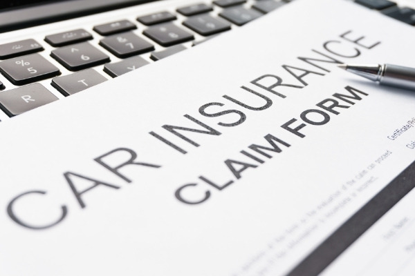 Car insurance claim form with pen